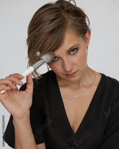 Girl with cosmetic brush on white background