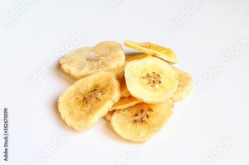 Pile of dry banana slices isolated on white background. Dried fruit chips