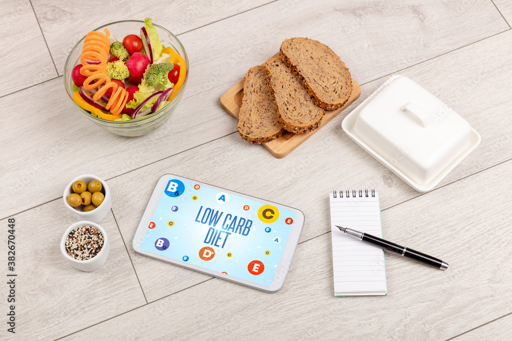Healthy Tablet Pc compostion with LOW CARB DIET inscription, weight loss concept Healthy Tablet Pc compostion with LOW CARB DIET inscription, weight loss concept