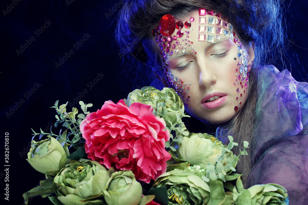 young woman with creative make up holding flowers young woman with creative make up holding flowers
