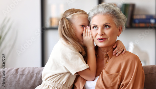 Foto Girl sharing secret with grandmother.
