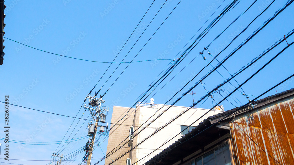 Blue sky and Japanese utility poles and wires Blue sky and Japanese utility poles and wires
