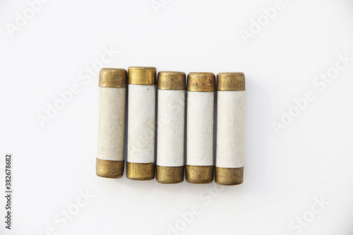 Old electric high-voltage fuses on a white background.