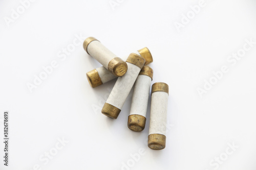 Old electric high-voltage fuses on a white background.