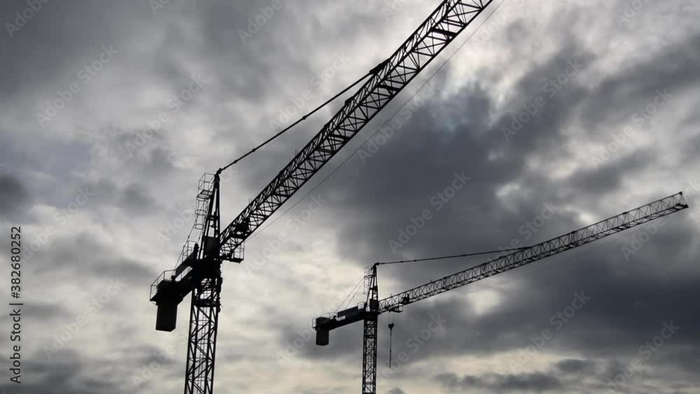 Two cranes under a cloudy sky Two cranes under a cloudy sky