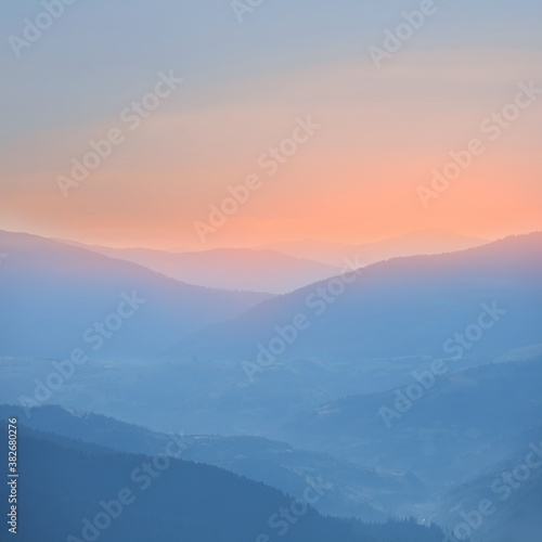 mountain chain silhouette in a blue mist before a dawn, early morning mountain background
