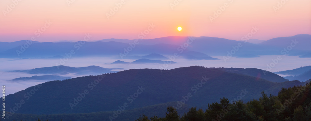 mountain chain silhouette in a blue mist at the dawn, early morning mountain background