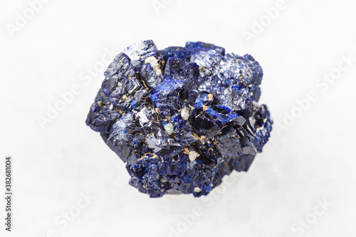 macro photography of sample of natural mineral from geological collection - raw Azurite mineral crystals from Jezkazgan, Kazakhstan on white marble background photo