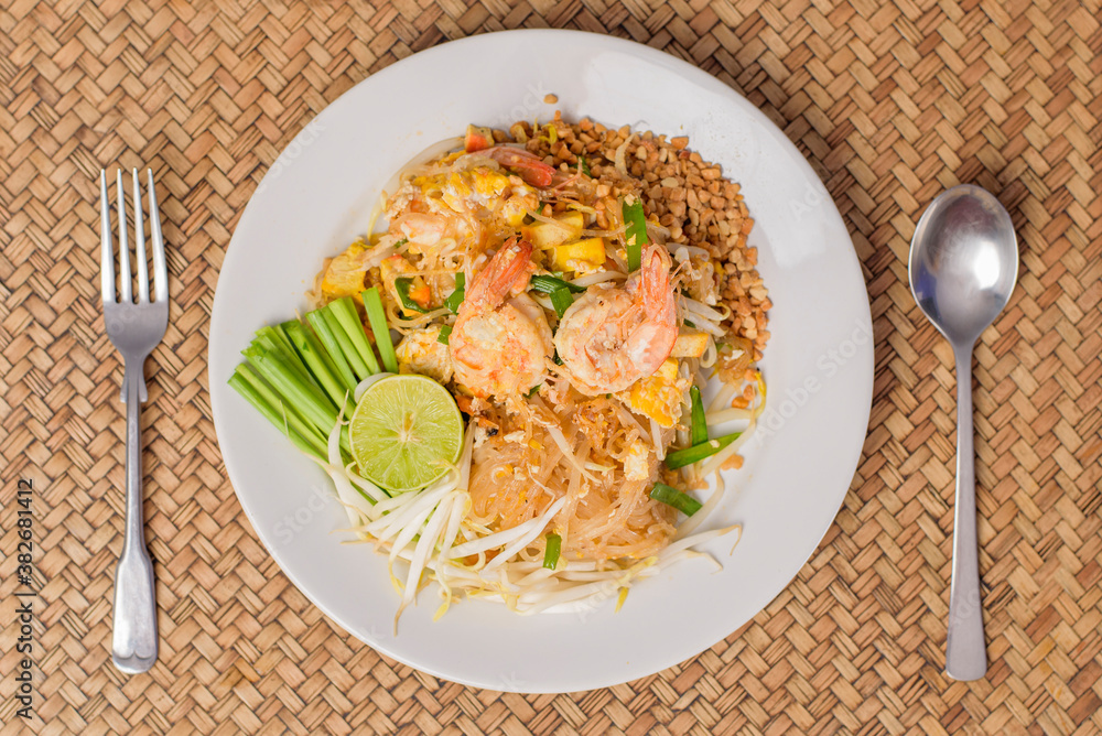 Top view of Thai traditional food Pad Thai Noodles with shrimp in dish on wooden table Top view of Thai traditional food Pad Thai Noodles with shrimp in dish on wooden table