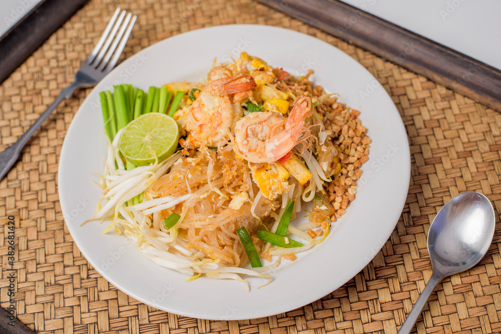 Thai traditional food Pad Thai Noodles with shrimp in dish on wooden table Thai traditional food Pad Thai Noodles with shrimp in dish on wooden table