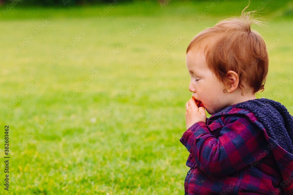 Young boy, just a toddler, eating a snack with blissful enjoyment Young boy, just a toddler, eating a snack with blissful enjoyment