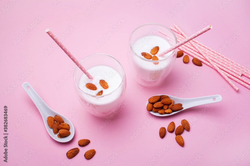 Two glasses of almond milk on a pink background. Lactose-free milk. Vegetarian food Two glasses of almond milk on a pink background. Lactose-free milk. Vegetarian food
