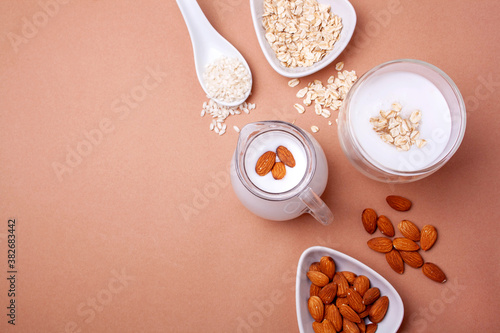 Lactose-free almond  rice and oat milk on a beige background. View from above