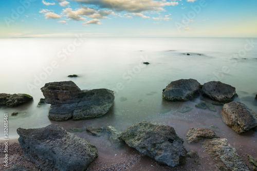 sea coast with stones at the early morning, quiet sea bay landscape