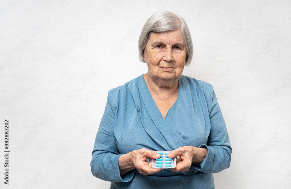 Fototapeta premium Elderly woman with pills in a hands