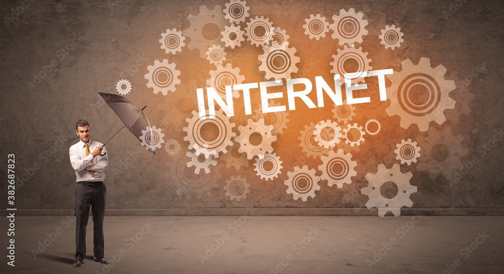 Businessman defending with umbrella from INTERNET inscription, technology concept Businessman defending with umbrella from INTERNET inscription, technology concept