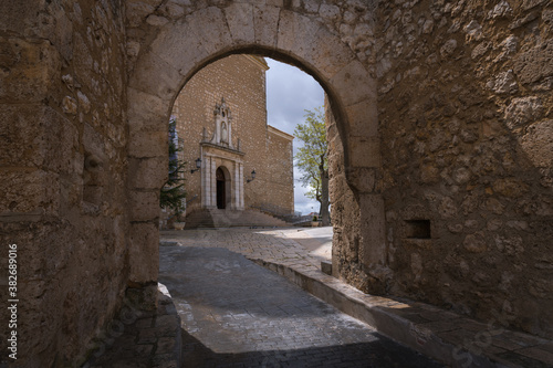 View of the main facade of the Church of Our Lady of the Assumption through the entrance portico to the church compound in Tarancón, Cuenca, Spain