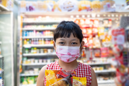 Asian little child girl shopping in mini mart