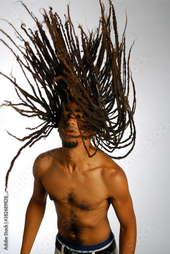 Canvas-taulu Young shirtless black man throwing dreadlocks in the air