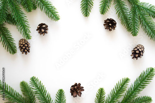 New Year background with green fir branches and pine cones isolated on white. Winter or Christmas template for your design with copy space.