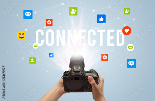 Using camera to capture social media content with CONNECTED inscription, social media content concept © ra2 studio