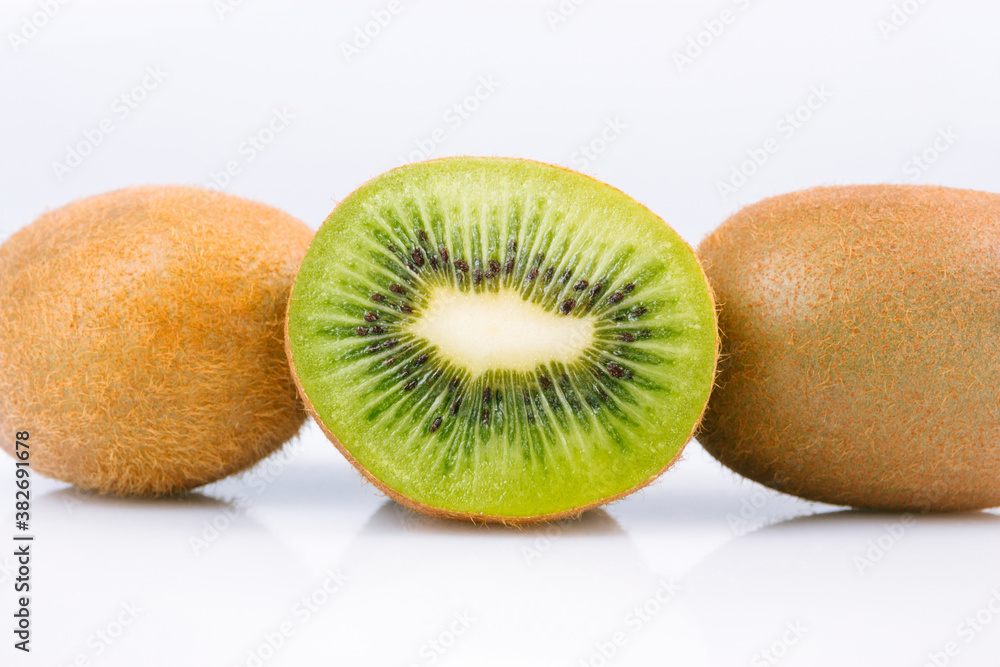 Ripe whole kiwi fruit and half kiwi fruit on bright background. Ripe whole kiwi fruit and half kiwi fruit on bright background.