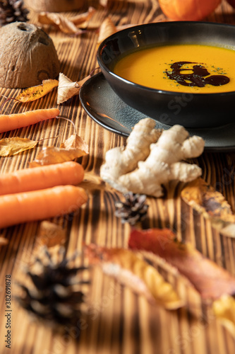 orange Suppe aus Kürbissen vom Hokkaido in einer Schale auf einem braunem Tisch aus Holz im Herbst zu Halloween photo