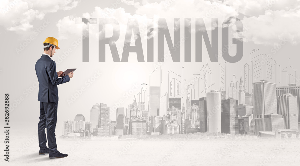 Young businessman with hard hat and TRAINING inscription, new business opportunity concept Young businessman with hard hat and TRAINING inscription, new business opportunity concept