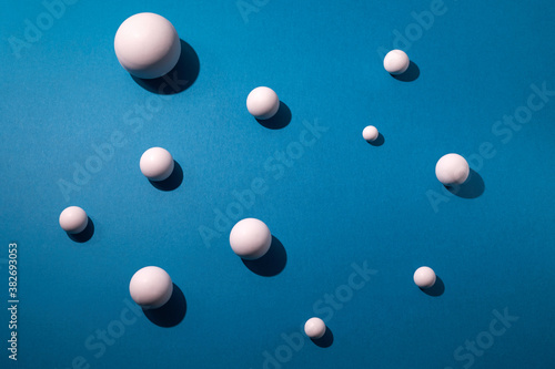 White balls on blue background. Flat lay, top view