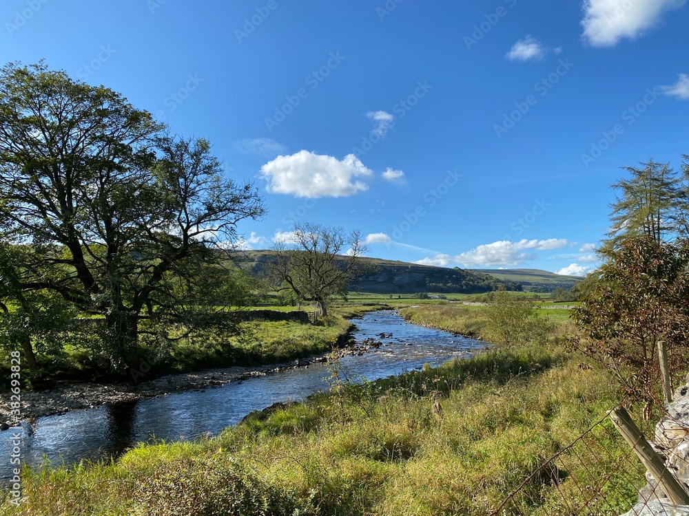 Looking up the valley, as the river Skirfare meanders down toward Kettlewell, with long grasses, wild plants and trees Looking up the valley, as the river Skirfare meanders down toward Kettlewell, with long grasses, wild plants and trees