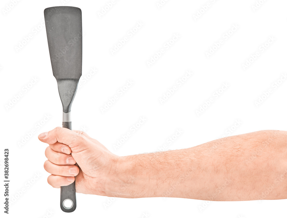 Male hands holding a spatula for frying. Isolated on gray background. Male hands holding a spatula for frying. Isolated on gray background.