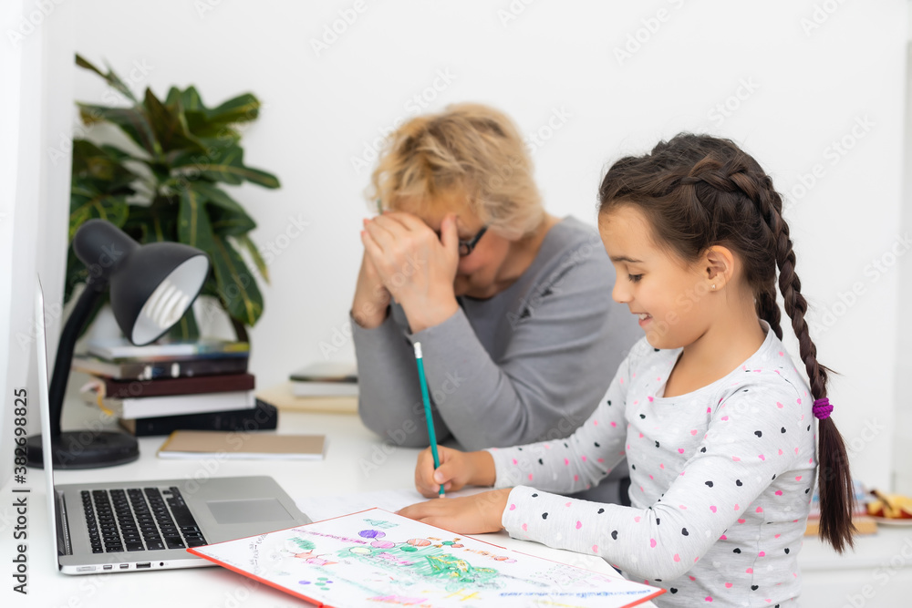 Helpful granny. Helpful loving granny assisting her cute granddaughter making homework Helpful granny. Helpful loving granny assisting her cute granddaughter making homework