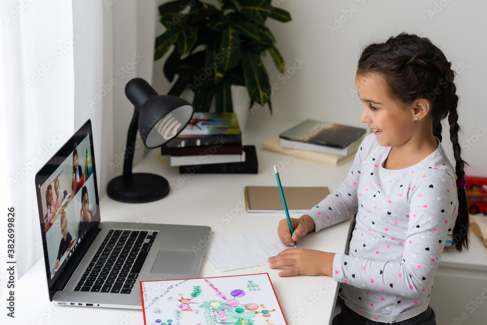 Little girl studying online using her laptop at home Little girl studying online using her laptop at home
