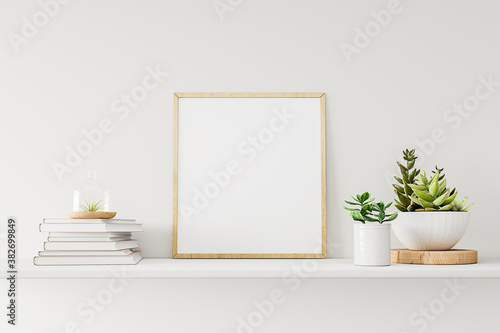 Home interior poster mock up with wooden frame, white vase and a pile of books on the white wall background. 3D rendering.