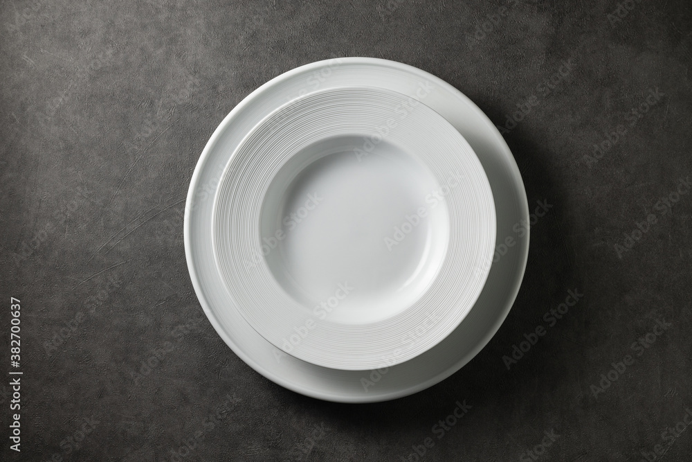 two beautiful modern plates on a dark gray concrete background, top view
two beautiful modern plates on a dark gray concrete background, top view