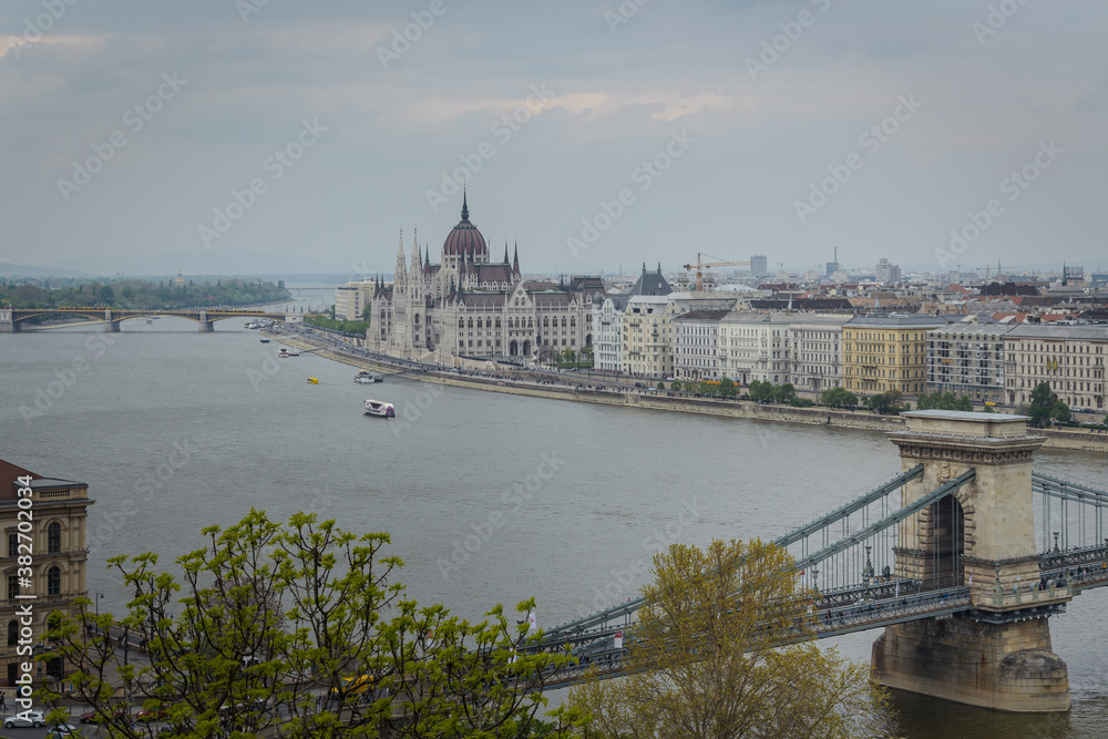 Budapest city landscape with the famous Chain bridge over the Danube river and the Parliament building in the background on a cloudy day, Hungary