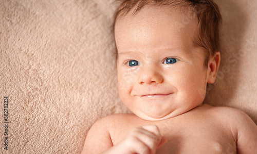 Portrait of a baby boy on a beige background.