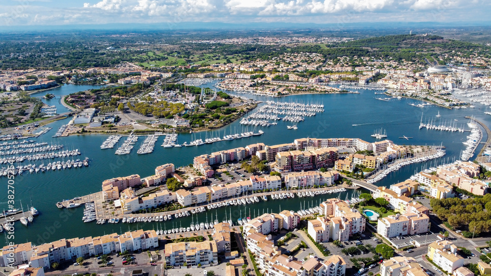 Aerial view of the Cap d'Agde sea resort on the South of France along the Mediterranean Sea - Artificial island in the marina with touristical amenities