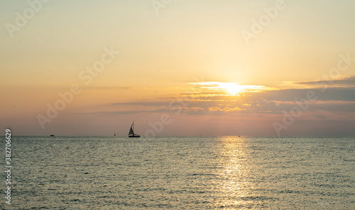 Obraz na plátně Amazing landscape  and sailboat in orange sunset