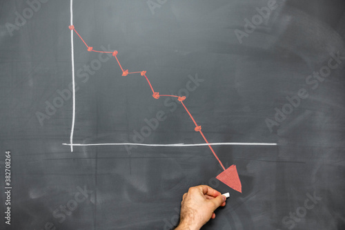 Photo person pointing red descending graph on blackboard