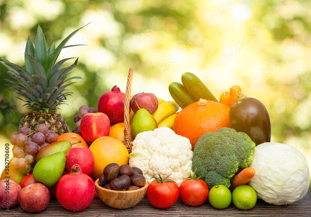 Group vegetables and Fruits Apples, grapes, oranges, pineapples, bananas in a wooden basket with carrots, tomatoes, guava, chili, eggplant, golden pod, green salad on wooden table in nature background Group vegetables and Fruits Apples, grapes, oranges, pineapples, bananas in a wooden basket with carrots, tomatoes, guava, chili, eggplant, golden pod, green salad on wooden table in nature background