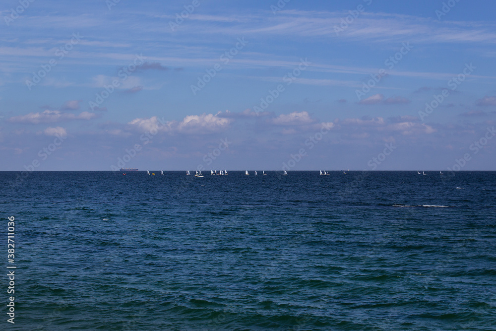blue sea water wave panoramic horizon view with boats and sky with clouds 