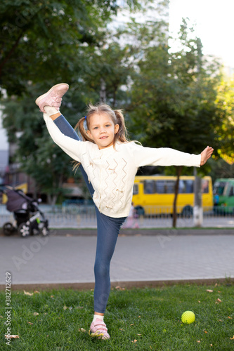 cute girl acrobat in the park shows twine