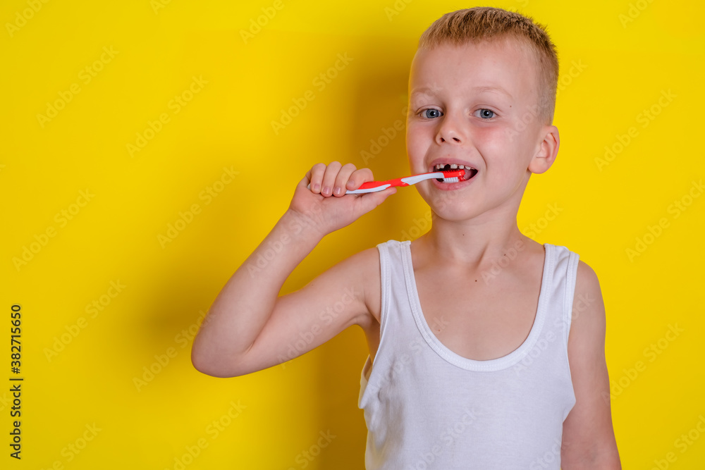 Child brushing teeth on a yellow background. dentistry and health concept. Child brushing teeth on a yellow background. dentistry and health concept.