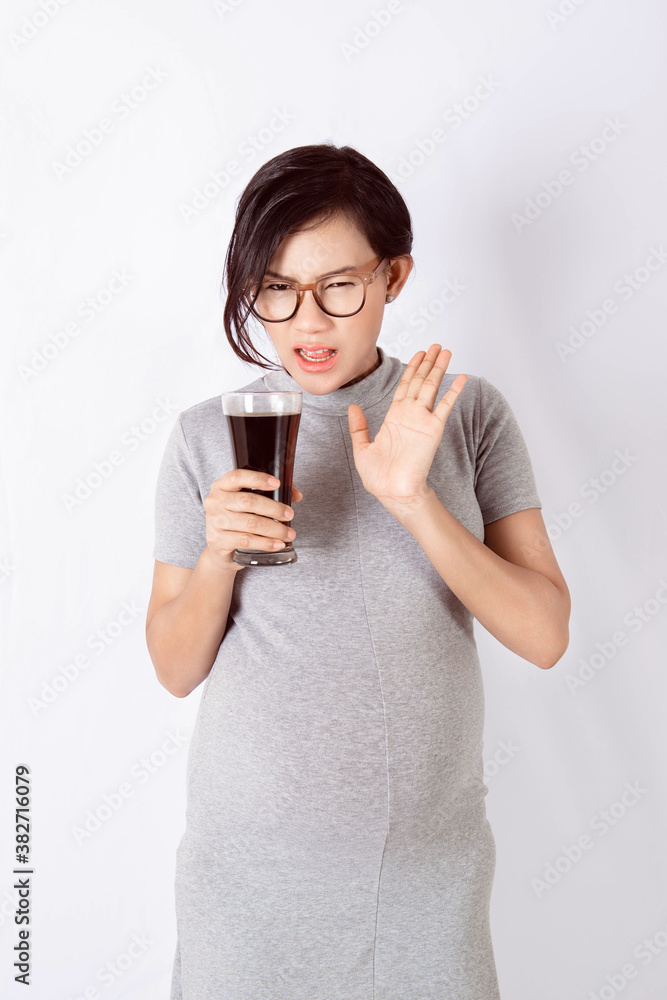 Asian pregnant woman Holding soft drinks, bad mood. Asian pregnant woman Holding soft drinks, bad mood.