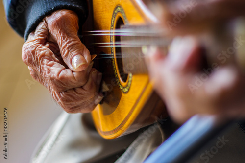 Old hands playing a mandolin
