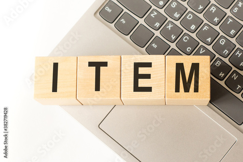 Word item. Wooden cubes with letters isolated on a laptop keyboard. Business Concept image. photo