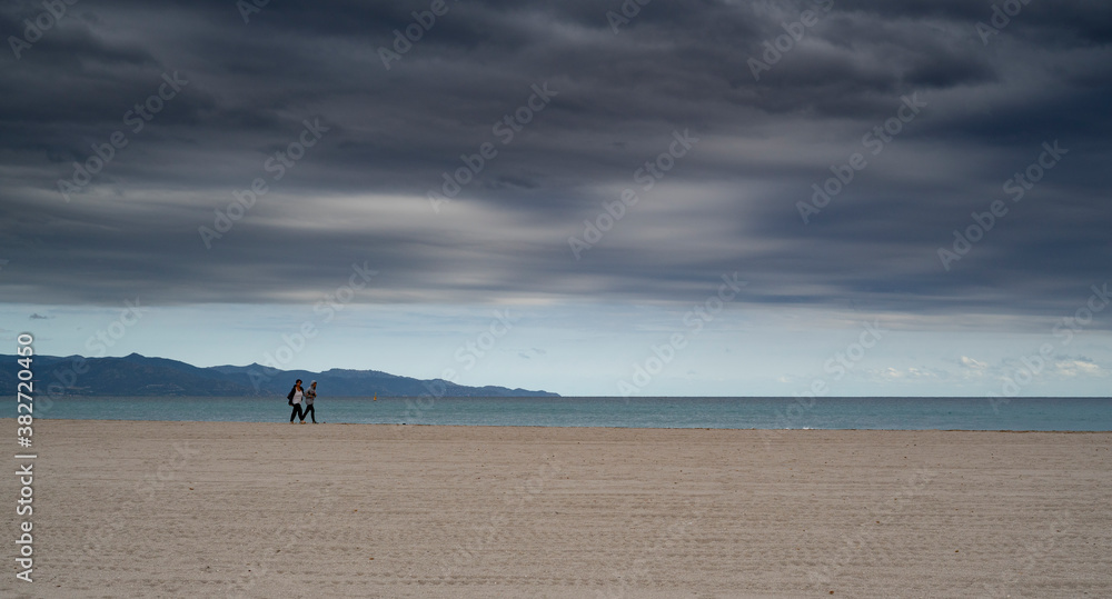 poetto beach with two people walking. Freedom concept