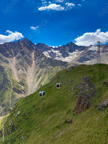 Cableway cabins on the background of mountains. Beautiful mountain summer landscape.