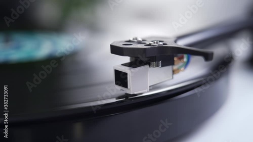 Close up of stylus or needle on turntable with vinyl record spinning photo